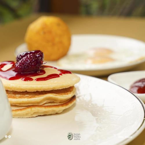 a stack of pancakes with fruit on a plate at Casa de Vista Alta in Mindo