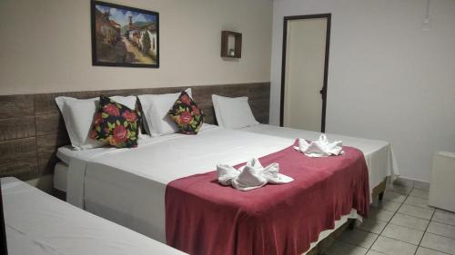 two beds sitting next to each other in a room at Pousada Villa Goyá in São José da Coroa Grande