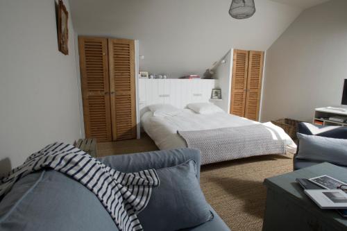 a living room with a bed and a couch at Appartement vue port in Port-en-Bessin-Huppain