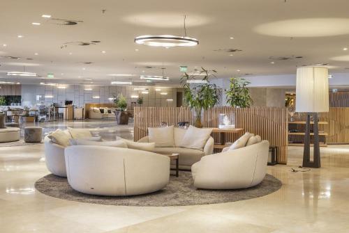 a lobby with white couches and tables in a building at Hotel Nacional Rio de Janeiro - OFICIAL in Rio de Janeiro