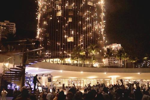 a crowd of people standing in front of a building with lights at Hotel Nacional Rio de Janeiro - OFICIAL in Rio de Janeiro