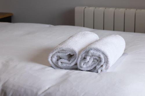 a pile of towels sitting on top of a bed at Pierside Apartments Deluxe Accommodation in Portsalon