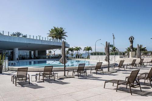 a row of chairs and a swimming pool at Hotel Nacional Rio de Janeiro - OFICIAL in Rio de Janeiro