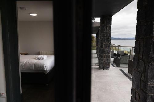 a bedroom with a bed and a view of the water at Pierside Apartments Deluxe Accommodation in Portsalon