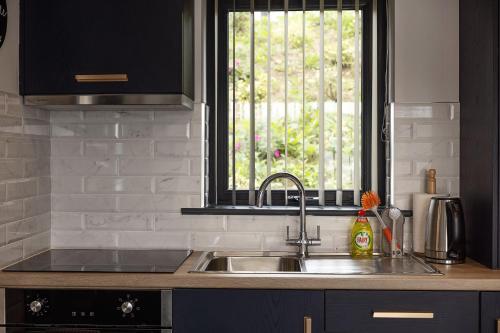 a kitchen with a sink and a window at Pierside Apartments Deluxe Accommodation in Portsalon