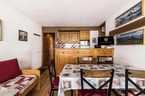 une cuisine avec une table et des chaises dans une pièce dans l'établissement Résidence Le Mustag - 3 Pièces 6/7 pers - LE MUSTAG - PLAGNE CENTRE MAE-5754, à Aime La Plagne