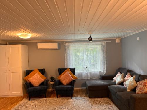 a living room with two couches and a window at Röd Stuga by Falunio in Södertälje