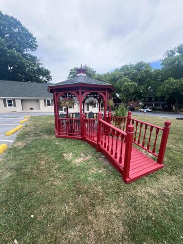 a red gazebo on the grass in a yard at Rodeway Inn & Suites Hershey Chocolate Avenue in Hershey