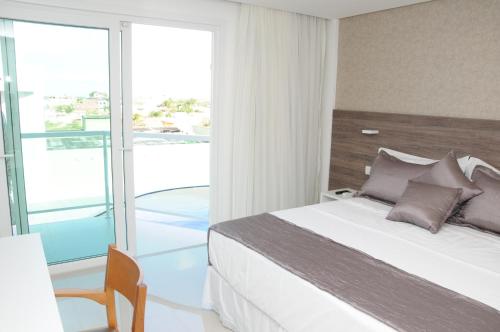 a bedroom with a bed and a balcony at Reserve Hotel in Surubim