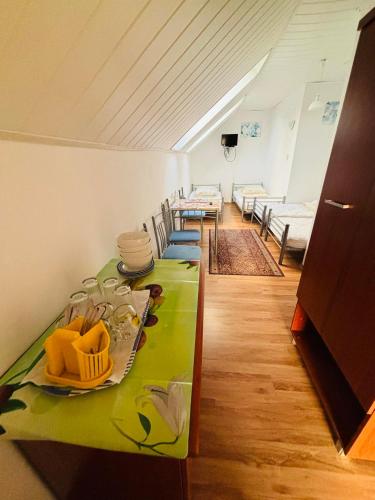 a room with a green table and chairs in it at VILLA BIAŁA in Okuninka