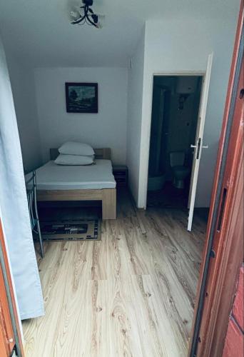 a bedroom with a bed and a wooden floor at VILLA BIAŁA in Okuninka