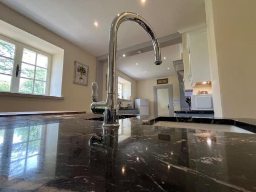 une cuisine avec un robinet sur un comptoir en marbre dans l'établissement Vaste propriété de charme au cœur du Périgord vert, à Siorac-de-Ribérac