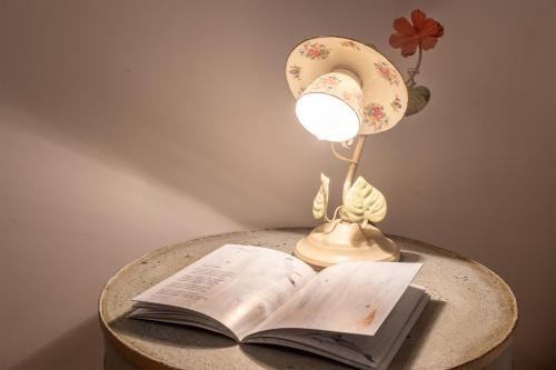 a table with a lamp and an open book at Le Scalette - Holiday Home in Calvi - ItalyWeGo in Calvi dellʼ Umbria