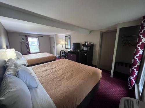 a hotel room with two beds and a television at Rodeway Inn & Suites Hershey Chocolate Avenue in Hershey