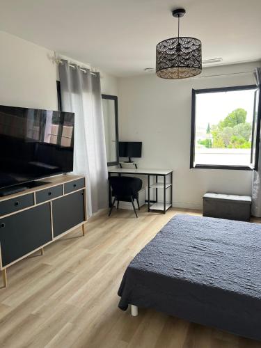 une chambre avec un lit et une télévision à écran plat dans l'établissement villa Wamal, à Mauguio