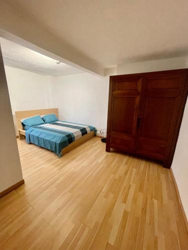une chambre avec un lit et un parquet dans l'établissement appartement chaleureux ecuson, à Montpellier
