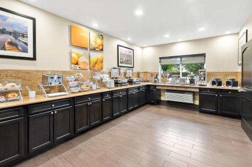 a large kitchen with a counter with food at Comfort Suites Portland Airport in Portland