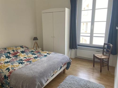 une chambre avec un lit, une chaise et une fenêtre dans l'établissement Idéalement placé, proche gare et plage du Sillon, à Saint-Malo