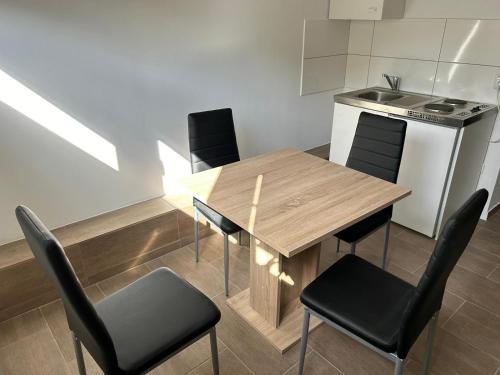 a kitchen with a wooden table and black chairs at Expresszimmervermietung in Duisburg