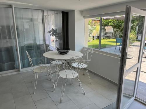 une table et des chaises dans une pièce avec une fenêtre dans l'établissement Appartement en RDJ de maison, à Savigny-sur-Orge