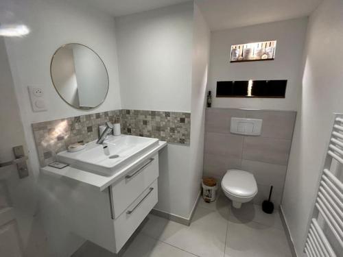 une salle de bain blanche avec un lavabo et des toilettes dans l'établissement Appartement en RDJ de maison, à Savigny-sur-Orge