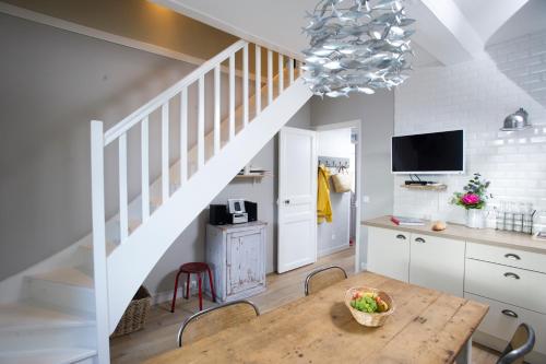 une cuisine et une salle à manger avec une table et un escalier dans l'établissement Appartement vue port, à Port-en-Bessin-Huppain
