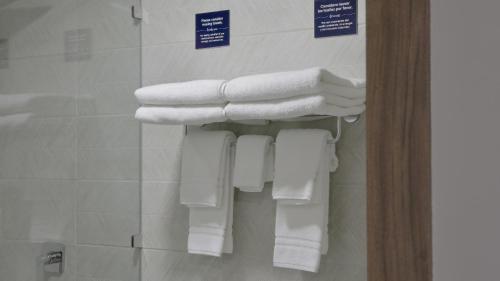 a pile of towels hanging on a wall in a bathroom at Cedrela in Comayagua