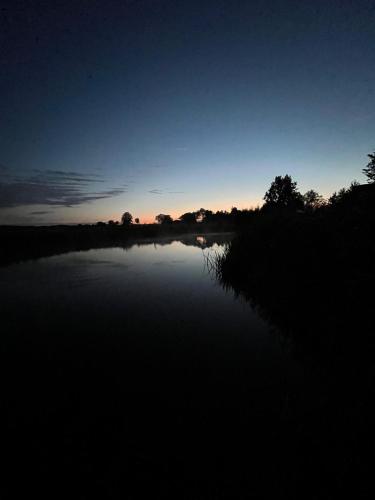 a view of a lake at night with the sun setting at Osada Karszewo, sauna bania, ryby in Karszewo