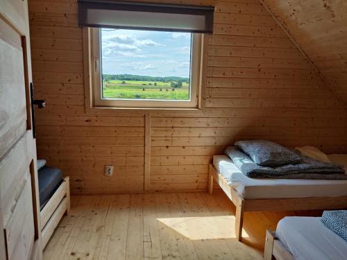 a room with two beds and a window at Osada Karszewo, sauna bania, ryby in Karszewo