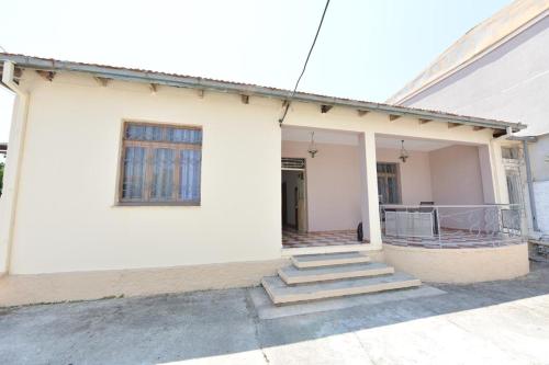 a white house with stairs leading up to it at Fishta Villa and Apartments in Shkodër