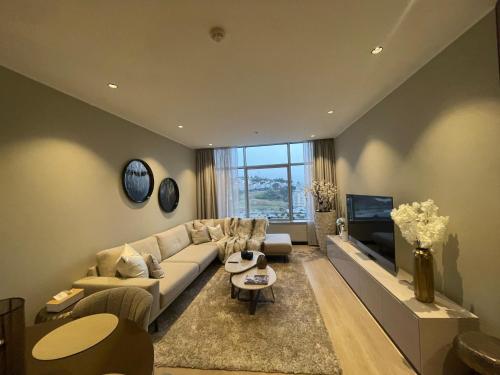 a living room with a couch and a tv at Hilton Tanger Penthouse 14 in Tangier