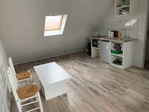 - une petite cuisine avec une table blanche et un comptoir dans l'établissement Appartement contemporain à Pierrelaye, 53 m², proche centre-ville, à Pierrelaye