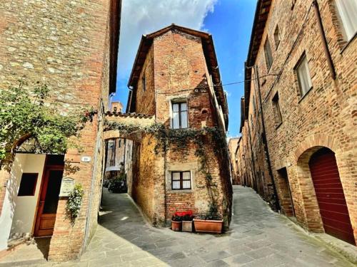 an alley in an old stone building with plants on it at La Casa di Lella in Città della Pieve