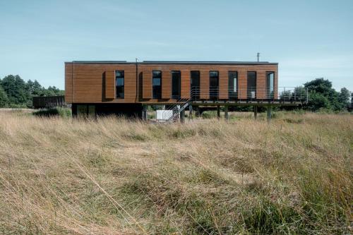 a building in the middle of a field at MAAJO Mākoņi in Strante