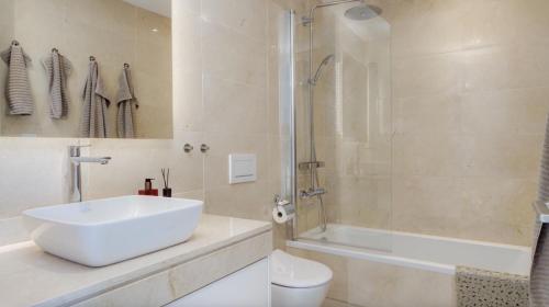 a bathroom with a sink and a shower and a toilet at Exclusive sea view townhouse with private plunge pool in La Valvega, La Cala de Mijas in La Cala de Mijas