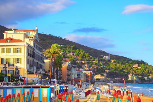 a beach with a bunch of umbrellas on the beach at Villa Monte Enrico - Pool And Whirlpool - Happy Rentals in Camporosso