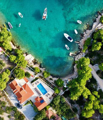 an aerial view of a house and boats in the water at Luxury Villa Kate - in Lucice Bay with turquoise sea, Amazing Seaviews, and Heated Pool in Milna
