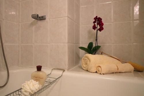 a bath tub with a bottle of soap and a flower at Petalo Bianco 100m from lake - Happy Rentals in Baveno