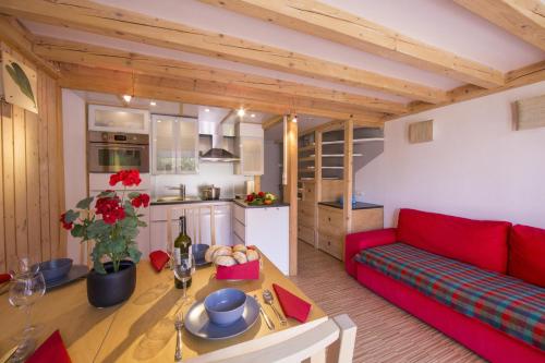 un salon avec un canapé rouge et une table dans l'établissement Résidence Grand Roc - Campanules 112 - Happy Rentals, à Chamonix-Mont-Blanc