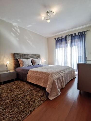 a bedroom with a large bed and a rug at Casa7pias in Ponte de Lima