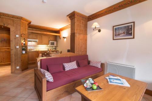 un salon avec un canapé violet et une table dans l'établissement Résidance Le Cristal - Grands Montets 11 - Happy Rentals, à Chamonix-Mont-Blanc