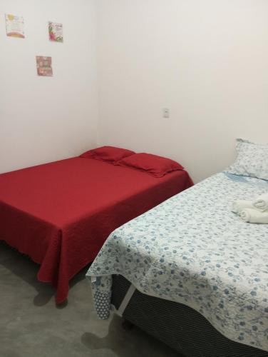 a bedroom with two beds and a red blanket at Pousada flor do sertão in Piranhas