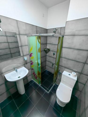 a bathroom with a toilet and a sink at Oval View by CityScape in Colombo