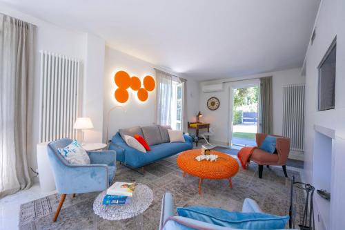 un salon avec un canapé bleu et des chaises dans l'établissement Villa Victor 100m from sea - Happy Rentals, à Marina di Massa