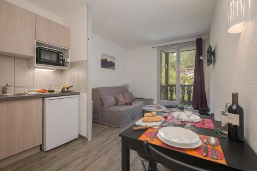 a kitchen and a living room with a table in a room at Chamonix Sud - Forclaz 213 - happy Rentals in Chamonix-Mont-Blanc