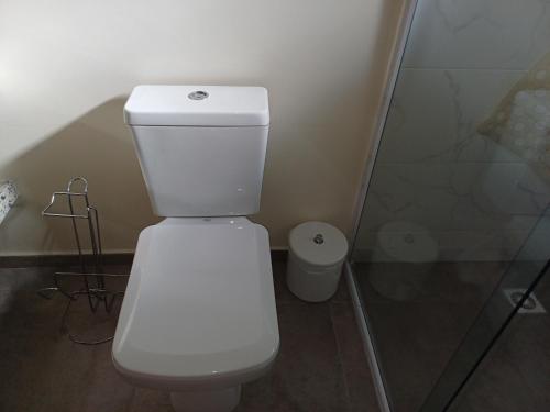 a white toilet in a bathroom with a shower at Vila Figueiredo das Donas - Suíte Espaço Gourmet in Bombinhas