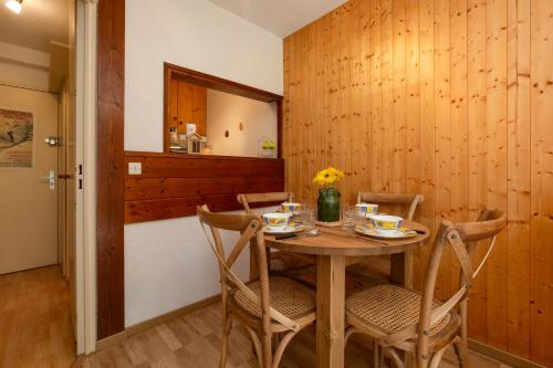 une salle à manger avec une table et des chaises en bois dans l'établissement Chamonix SUD - Jonquilles 118 - Happy Rentals, à Chamonix-Mont-Blanc