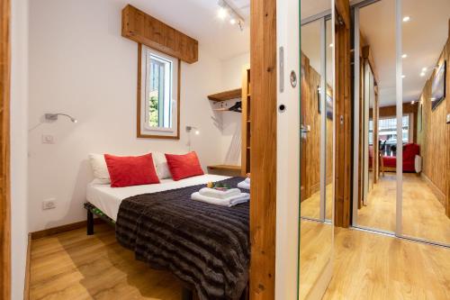 une chambre avec un lit avec des oreillers rouges dans l'établissement Appartement Clos du Savoy E1 - Happy Rentals, à Chamonix-Mont-Blanc