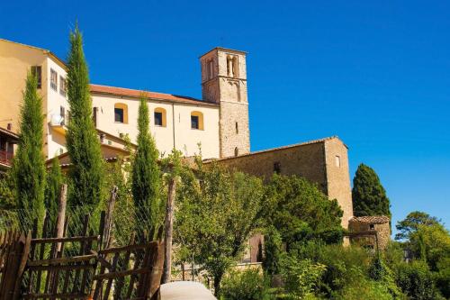 a building with a clock tower on top of it at Villa Borgiano - Happy Rentals in Scansano