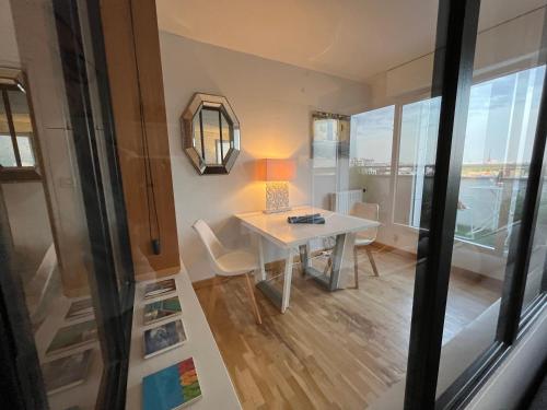 une petite chambre avec une table, des chaises et une fenêtre dans l'établissement Eiffel tower view appartment, à Suresnes